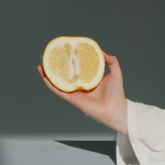Mano de mujer sujetando limón cortado